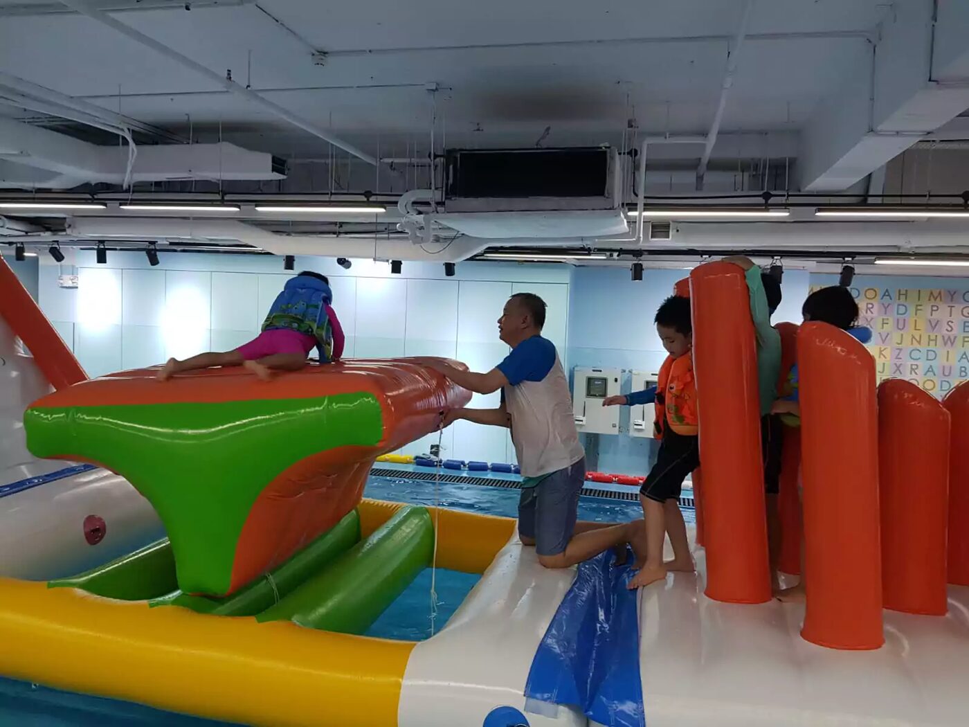 Coach helping children over the inflatable summit